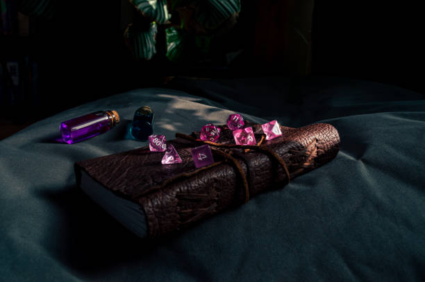 Set of pink RPG dice on a leather bound notebook stock photo