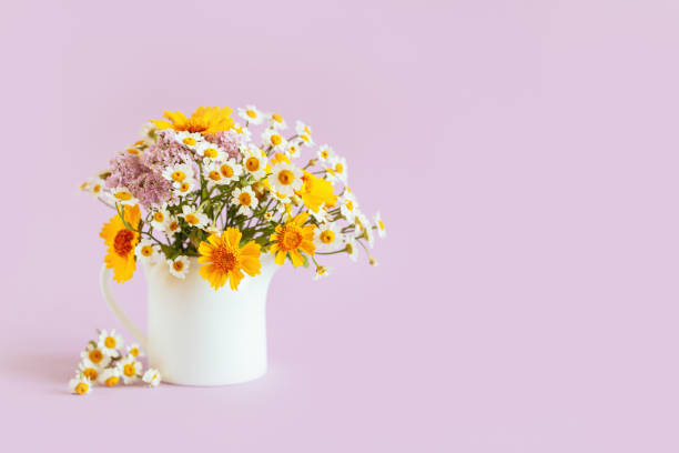 istock Beautiful summer flowers in a white jar on a pink background. Selective focus. 1332203011