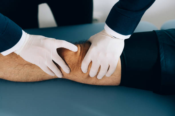 istock Physical Therapy: Therapist In Gloves Touchig Patient Knee 1332205402