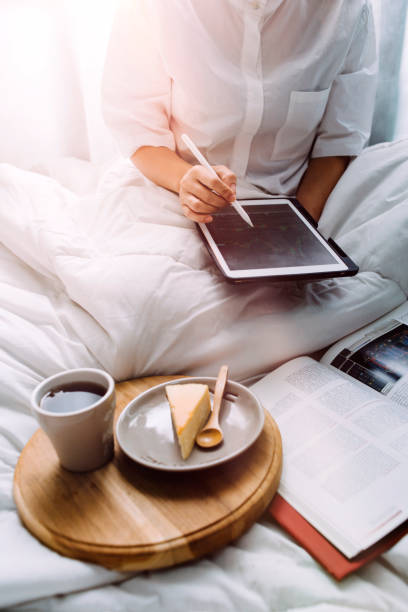 istock Senior stylish woman taking notes in notebook while using laptop at home. Old freelancer writing details on book while working on laptop in living room. Focused cool lady writing notary in notepad 1332209125