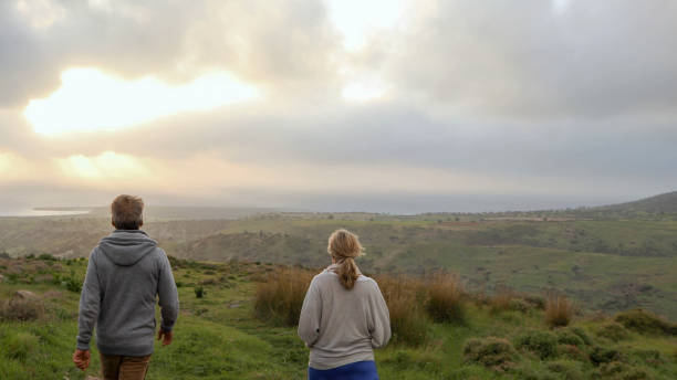 istock Mature couple walks through meadow at sunrise 1332209884