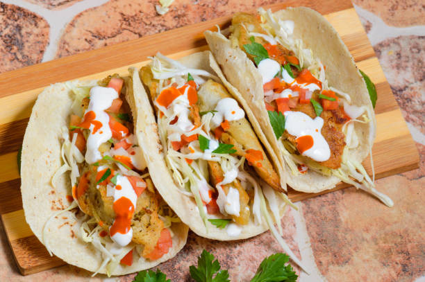 Baja California Style Fish Tacos With Toppings Baja California style fish tacos with toppings and salsas. Ensenada style tacos baja california peninsula stock pictures, royalty-free photos & images
