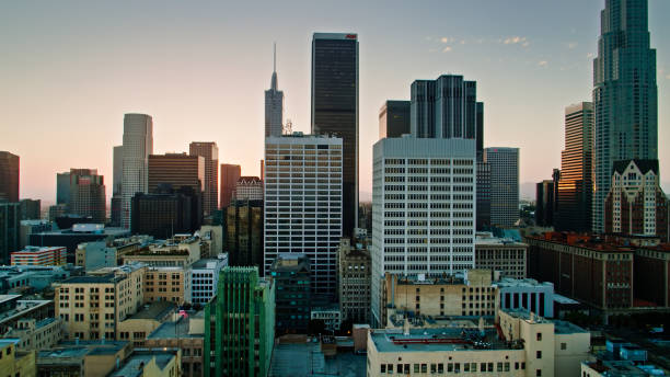 Aerial shot of Downtown Los Angeles at dusk, with the sun setting behind financial district skyscrapers.