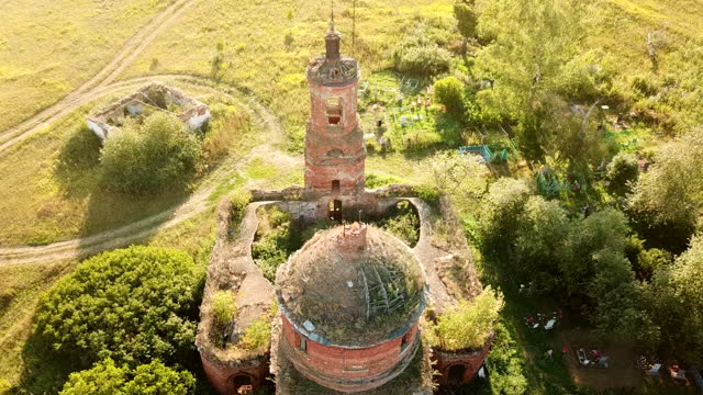 Aerial view of an old ruined Orthodox church with a churchyard in rural Russia