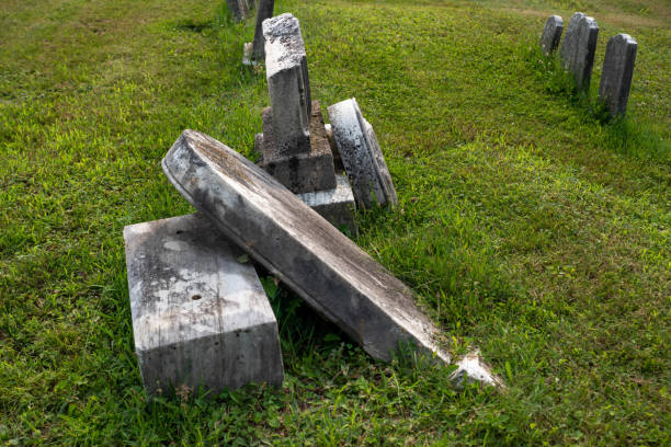 istock Ancient broken toppled gravestones in a green grass cemetery 1332220585