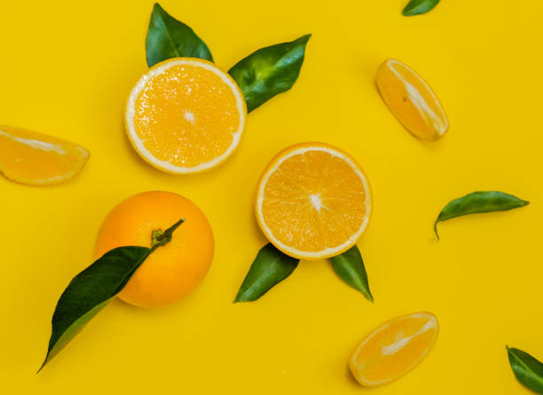 istock Orange in pieces on yellow background 1332220604