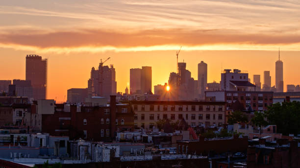 istock Drone Shot of Brooklyn with Setting Sun Shining Between Manhattan Skyscrapers 1332220635