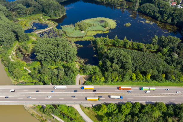 istock Traffic on Highway Among Forests and Lakes 1332222978
