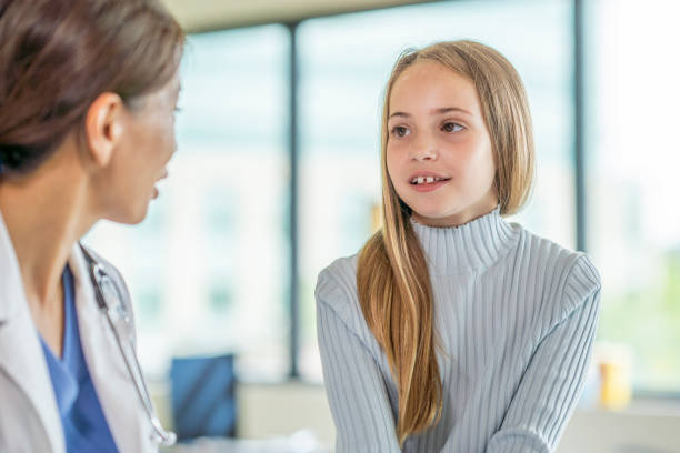 istock Elementary aged girl visits the doctor 1332226505
