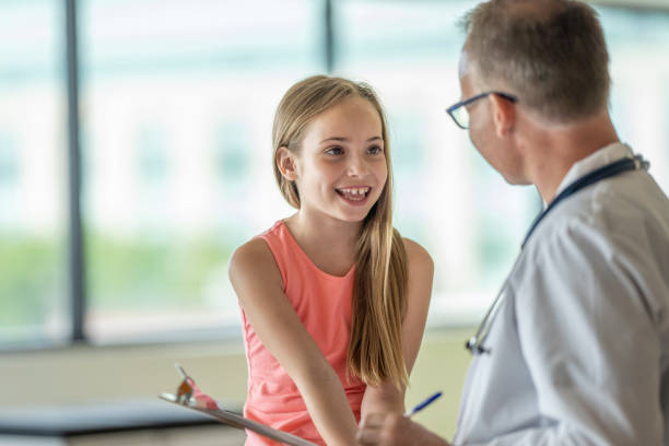 istock Elementary aged girl visits the doctor 1332226513