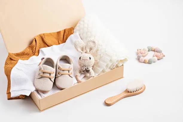 Photo of Gift basket with gender neutral baby garment and accessories. Care box of organic newborn cotton clothes