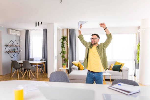 istock Happy young man holding paperwork and celebrating. 1332229851