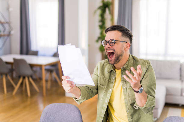 istock Happy young man holding a document and celebrating. 1332229967