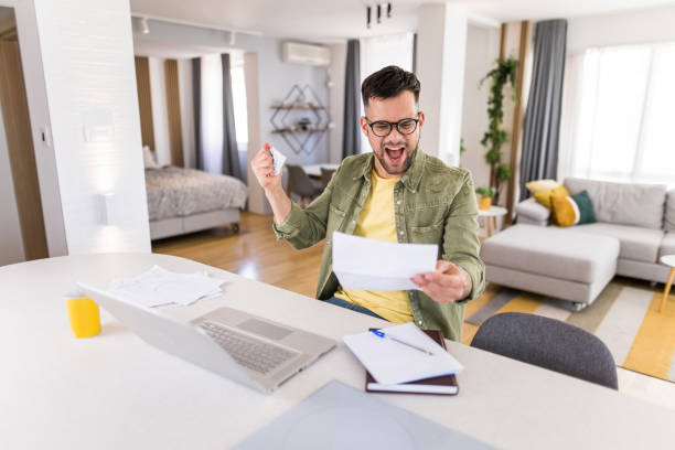 istock Happy young student going through paperwork and celebrating. 1332230529