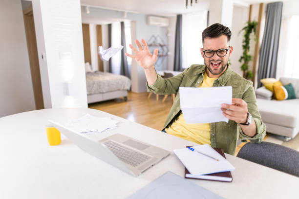 istock Frustrated young man reading from a document at home. 1332231383
