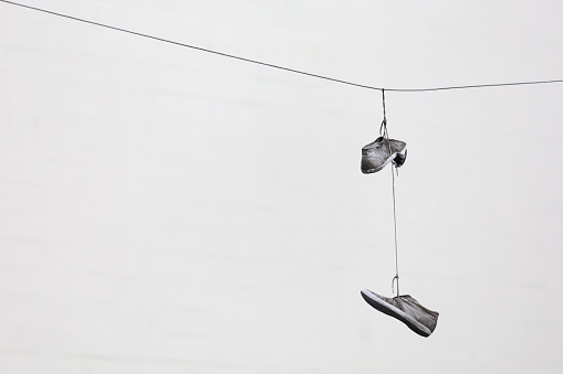 the image of shoes hang on wires