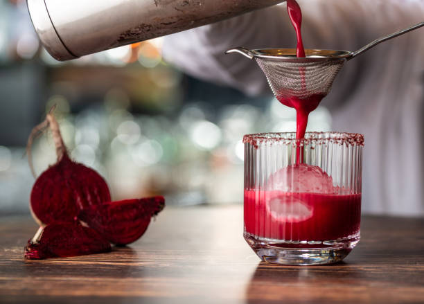 alkoholisches rote-bete-cocktailgetränk in elegantem glas auf holztisch. - chenopodiacea stock-fotos und bilder