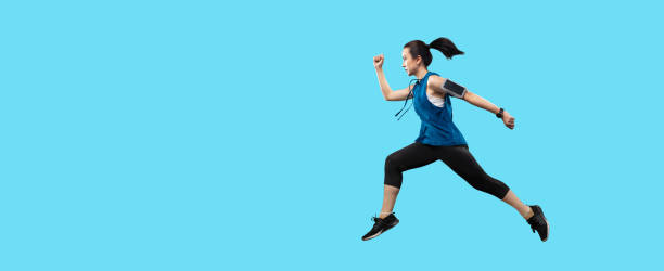 chemin d’écrêtage jeune femme active asiatique courant et sautant isolé en studio sur banderole fond de couleur bleu clair. - jumping women running vitality photos et images de collection