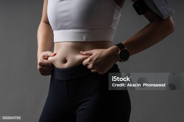 Closeup Body Of Woman In Sportswear Healthy Exercise With Fat On Belly Problem Stock Photo - Download Image Now