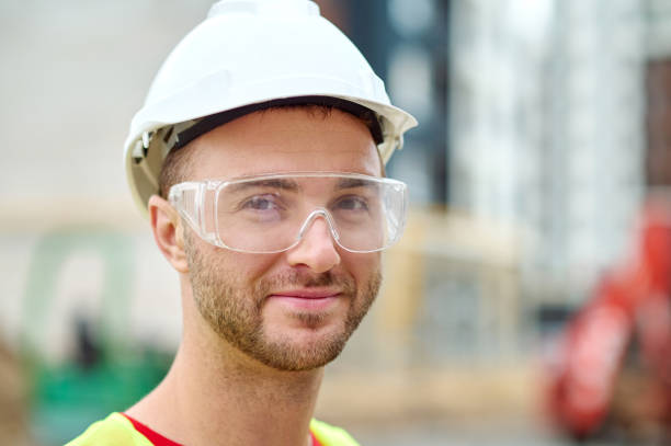 istock Pleased attractive builder in safety goggles posing for the camera 1332251284
