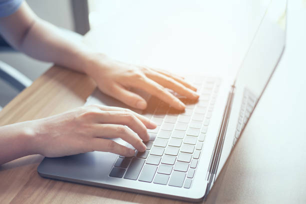 istock closeup man hand using laptop on desk office place, man is working remotely at home 1332254455
