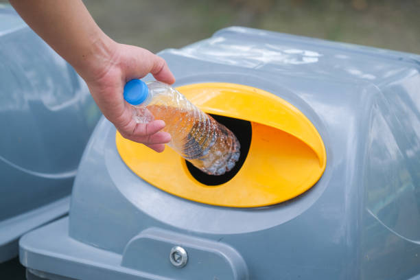 istock Hand holding plastic bottle and throwing into the garbage for recycle. 1332258724