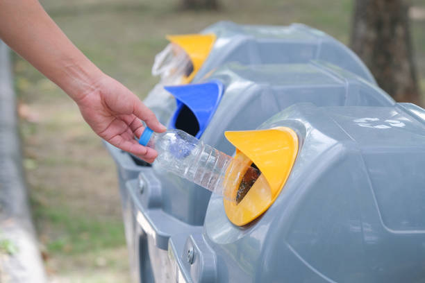 istock Hand holding plastic bottle and throwing into the garbage for recycle. 1332258746