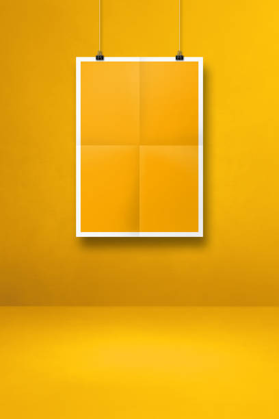 istock yellow folded poster hanging on a clean wall with clips 1332263442