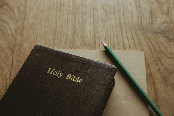 istock Holy bible with note book and pencil on wooden table, copy space 1332264488