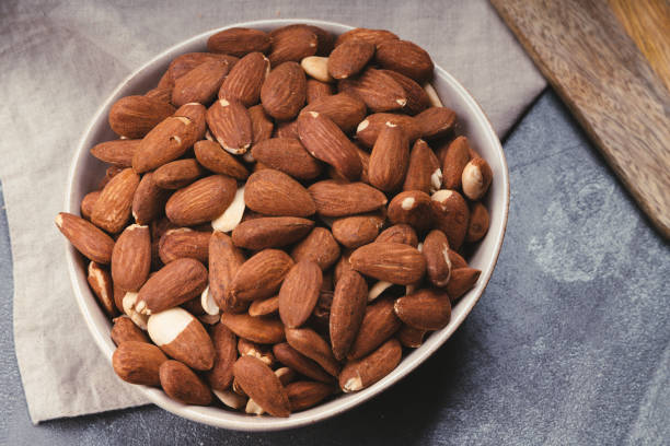 istock Ceramic bowl with natural almonds on linen towel 1332268165