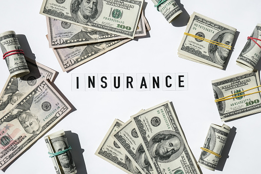 Text INSURANCE around US dollar banknotes. Health, life, home, car Insurance. Insurance business concept. Business budget of wealth and prosperity finance. Health care or medicare insurance and vaccination costs. Financial crisis. Covid-19 crimes