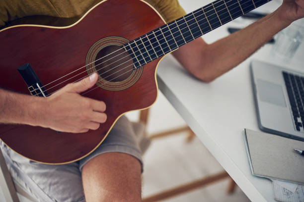istock Man playing acoustic guitar at home. 1332269623