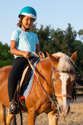 Cute little girl riding a horse.