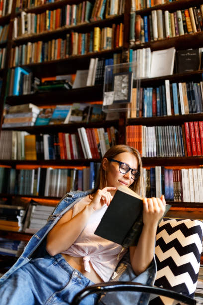 istock Young female student study in the library holding book , education concept 1332272863