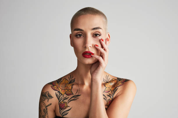 retrato de estudio de una hermosa joven posando sobre un fondo gris - cabeza afeitada fotografías e imágenes de stock