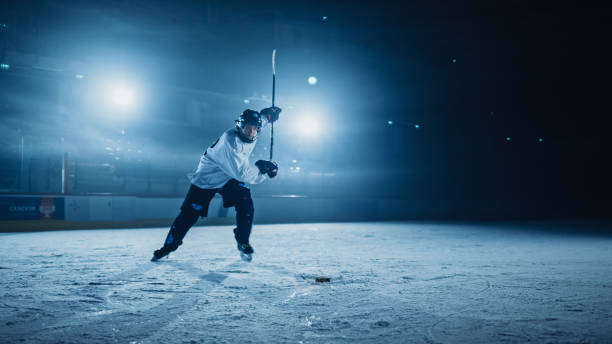 ice hockey rink arena: tiro professionistico, colpire, stricking the puck con bastoni da hockey. atleta che segna un gol. drammatico wide shot, illuminazione cinematografica. - hockey su ghiaccio foto e immagini stock