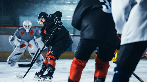 istock Ice Hockey Rink Arena: Professional Forward Player Masterfully Dribbles, Breaks Defense, Ready to Hit the Puck with Stick to Score a Goal. Important and Tension Moment. 1332278075