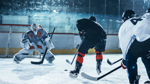 istock Ice Hockey Rink Arena: Professional Forward Player Masterfully Dribbles, Breaks Defense, Ready to Hit the Puck with Stick to Score a Goal. Important and Tension Moment. 1332278084