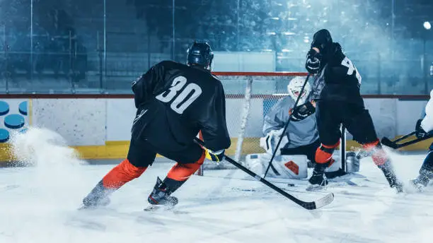 Photo of Ice Hockey Rink Arena: Professional Forward Player Attacks, Shows Expert Stickhandling, Dribbles, Handling Puck with Hockey Stick Beautifully, Defense Unable to Intercept.