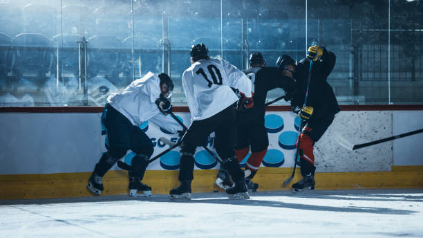istock Ice Hockey Rink Arena: Professional Defender Player Attacks, Boarding Attacker Aggressively, Taking away the Puck. Competitive Intense Game with Amazing Skills, Speed, Energy, Power. 1332278127