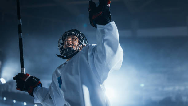 профессиональный хоккеист празднует победу, поднимает руки. - youth league стоковые фото и изображения