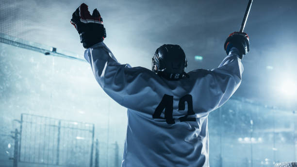 jugador profesional de hockey sobre hielo celebrando la victoria, levantando los brazos. - clothing team sport serious viewpoint fotografías e imágenes de stock