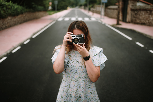 Young woman taking a picture with a retro / vintage camera