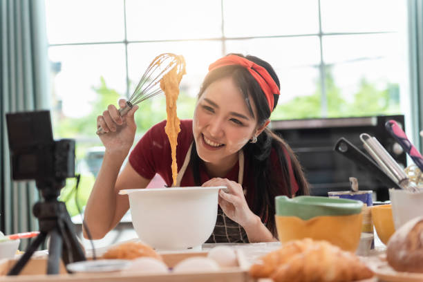 행복한 아시아 여성은 쿠키를 요리하고 부엌에서 재미를. 그녀는 그녀의 요리 동영상 블로그에 대한 비디오를 제작. - baking cake making women 뉴스 사진 이미지