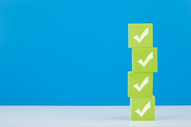 checkmarks on four light green blocks on white table against blue background with copy space - checkbox check mark questionnaire checklist imagens e fotografias de stock