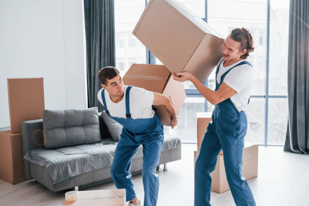 istock Heavy boxes. Two young movers in blue uniform working indoors in the room 1332289804