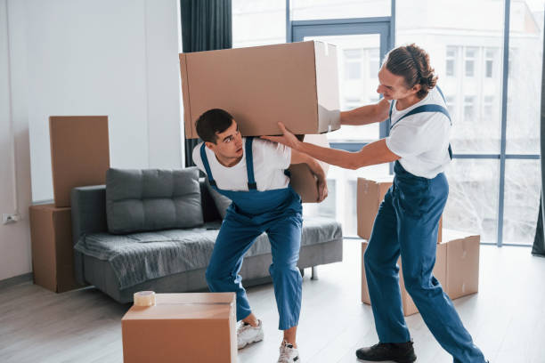 istock Heavy boxes. Two young movers in blue uniform working indoors in the room 1332289824