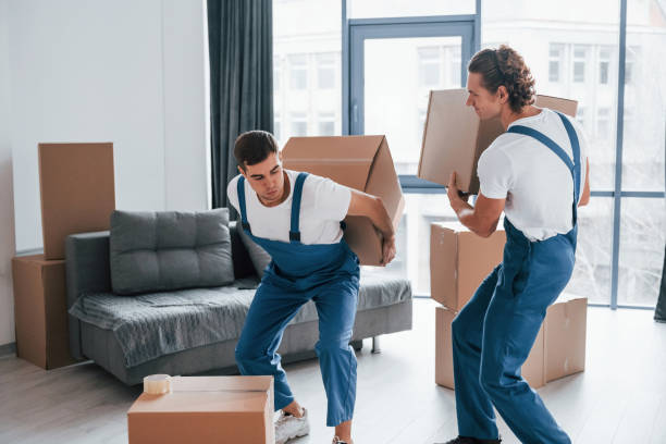 istock Heavy boxes. Two young movers in blue uniform working indoors in the room 1332289829