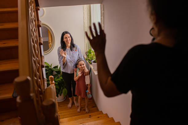 Mother and daughter waving back to a nanny, before they leave for the school Before the mother and daughter leaving for school, they waving back to their maid/nanny while she taking care of the little girl sibling, wishing her an exciting first day of the school nanny stock pictures, royalty-free photos & images