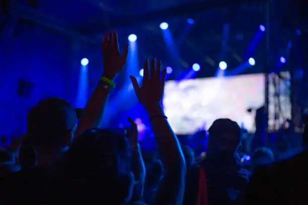 Photo of youth dancing at a concert at night